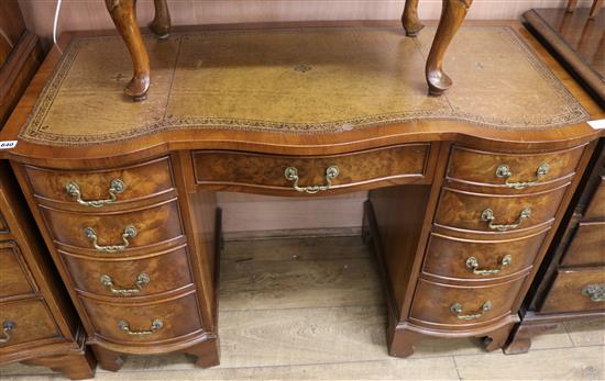 A walnut kneehole desk, with serpentine front, W.115cm